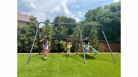 Multiple kids playing on a large metal swing set.